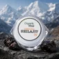 Organic Virsa Himalayan Shilajit 12g pure mineral resin jar placed on Himalayan rocks with snow-capped mountain background